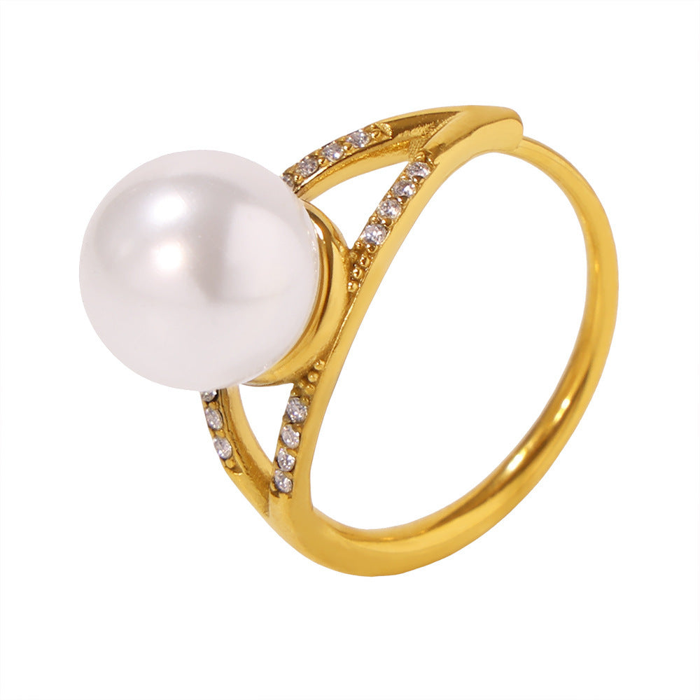 Statement gold ring with a large pearl and diamond embellishments shown on a white background