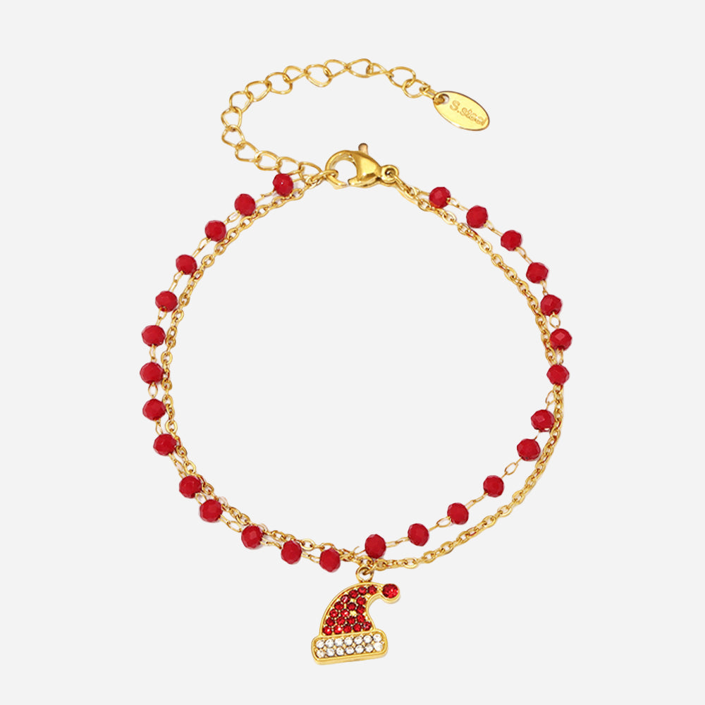 Gold bracelet with red beads and a heart charm on a white background