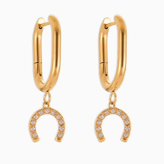 Gold hoop earrings with horseshoe charms on a white background