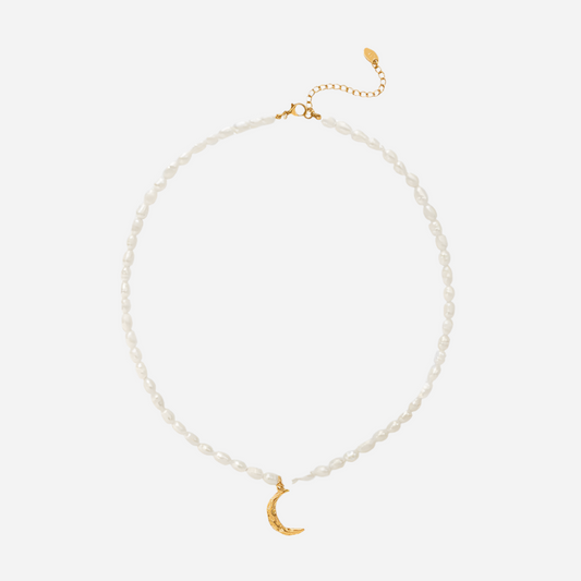 Pearl necklace with a gold crescent moon pendant on a white background