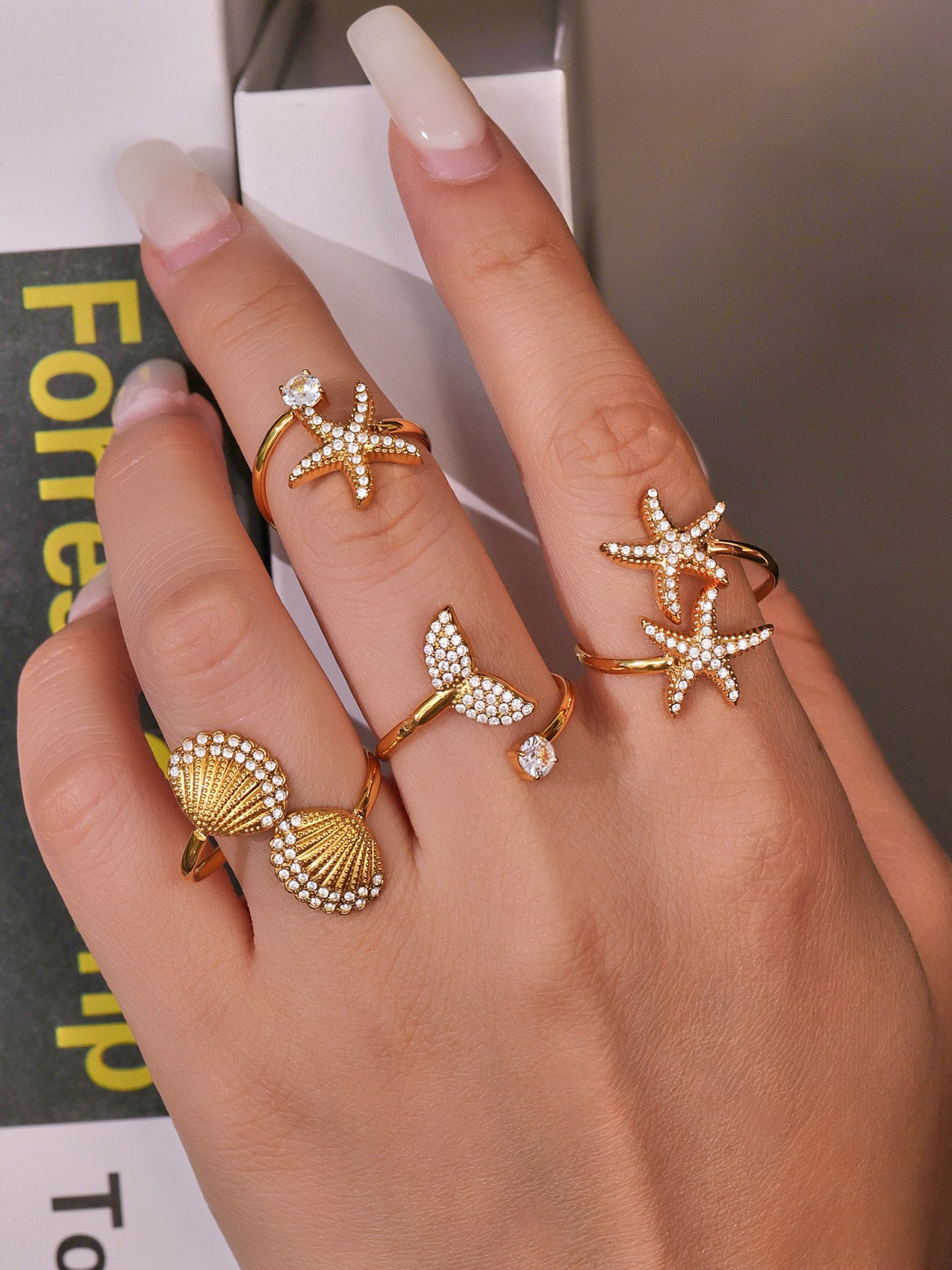 Model wearing 18K gold starfish star ring, ocean inspired jewelry with cubic zirconia sparkle
