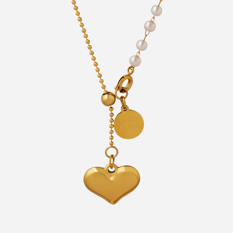 Gold necklace with heart pendant and pearl beads on a white background