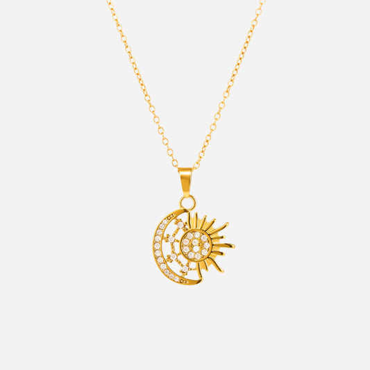 Gold necklace with a sun and moon pendant on a white background