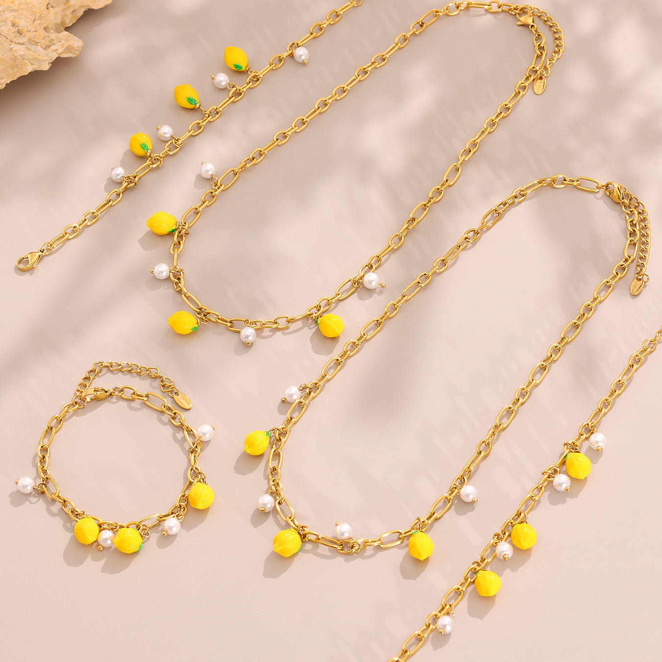 Gold necklaces with yellow and white beads on a beige background