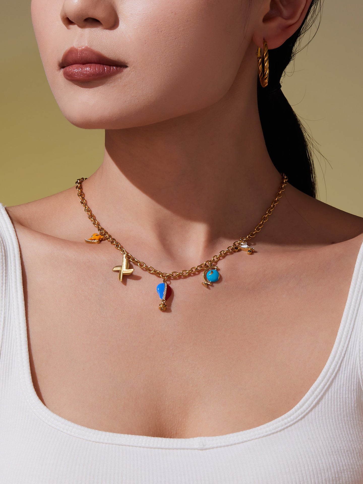 Model wearing colorful charm pendant necklace with playful enamel pendants